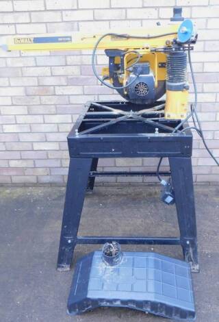 A DeWalt DW721KN radial arm saw, with cast iron arm and four roller bearings to the motor head, single phase, 2000 watt motor, on a wooden table or stand, with instructions.