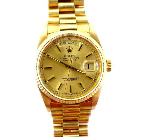 A Rolex Oyster Perpetual Day-Date 18ct gold gentleman's wristwatch, with gilt coloured dial having applied stick batons surrounded by a linked minute track, interspersed by Roman numerals. Having two apertures for day and date, the latter with trademark c