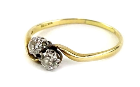 A two stone diamond set twist ring, with round brilliant cut diamonds each approx 0.15cts, with twist design shoulders, on a thin band, yellow metal, marked SIR JB, ring size N½, 1.9g all in.
