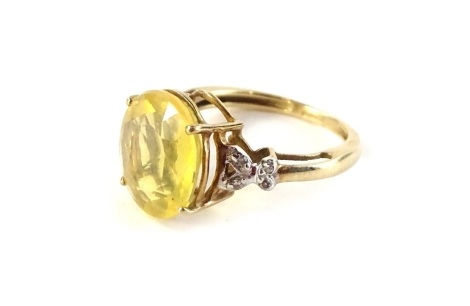 A 9ct gold dress ring, set with central oval cut yellow stone, and white stone set shoulders, in a cross design, ring size K, 2.5g all in.