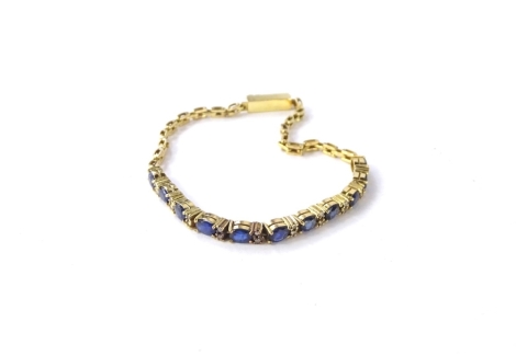 A sapphire and diamond bracelet, with central design of eleven oval cut sapphires in four claw setting, broken by two round brilliant cut tiny diamonds, each in two claw setting, with modern single and two bar alternating design bracelet, yellow metal, un