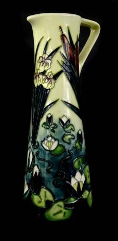 A Moorcroft pottery ewer, with tube line decoration of lilies, lily pads etc., impress marks to underside copyrighted for 1995, 24cm H.