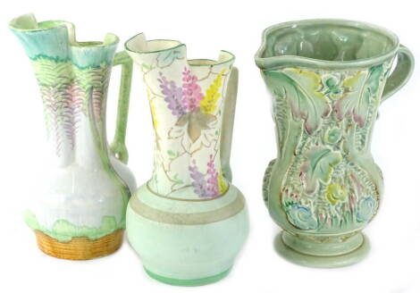 Three items of Beswick pottery to include two similar Art Deco ewers, each decorated with flowers or leaves and a two handled relief moulded vase shape No.679.