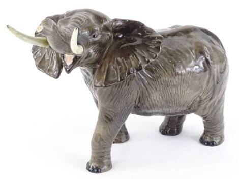 A Beswick pottery model of an elephant, with trunk raised etc, 38cm L.