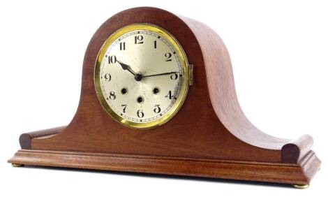 An early to mid 20thC mahogany Napoleons hat shaped mantel clock, the circular dial with Arabic Numerals and Westminster chime and bun feet, 54cm W.