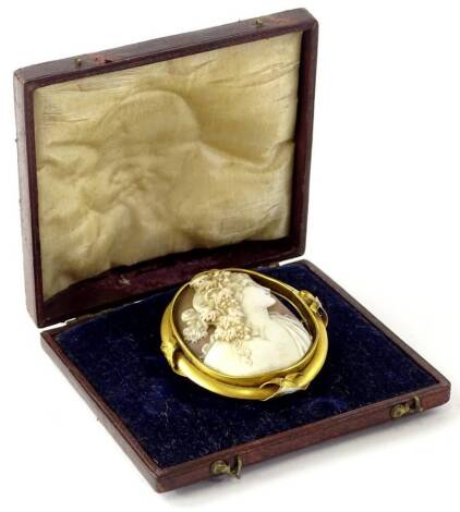 An early 20thC shell cameo brooch, depicting maiden with floral vines to hair, in a gilt metal frame, cross design four points, the cameo (AF), 5.5cm x 6cm, in fitted case.