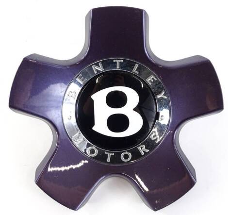 A Bentley motor car wheel hub insert, in a shade of metallic purple, 17cm dia.