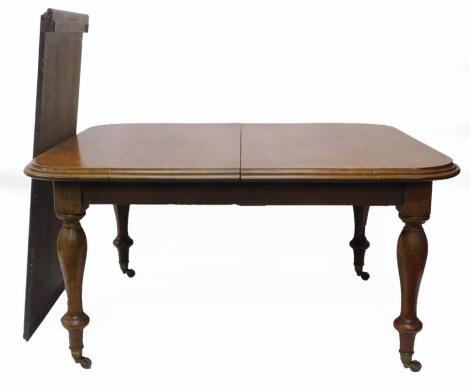 A Victorian mahogany extending dining table, the rectangular top, with a moulded edge, on turned legs, with brass castors, one loose leaf, the top 123cm x 197cm.