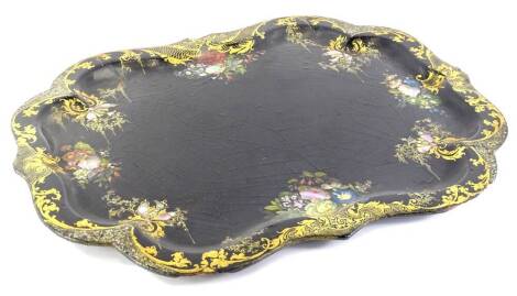 A Victorian papier mache tray, with a shaped edge, inlaid in mother of pearl, and painted in gilt, with scrolls, etc., on a black ground, (AF), 62cm W.