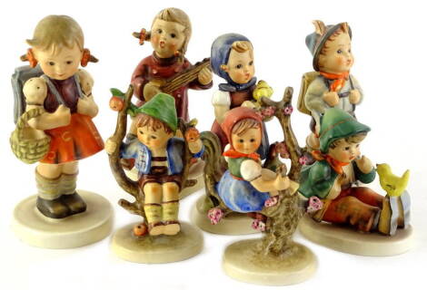 A collection of seven Goebel Hummel figures, to include girl with satchel and basket, a girl in a tree, etc.