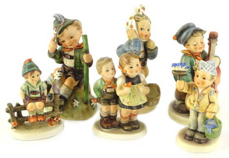 Six Goebel Hummel figures, to include boy playing a cello, boy on a fence, etc.