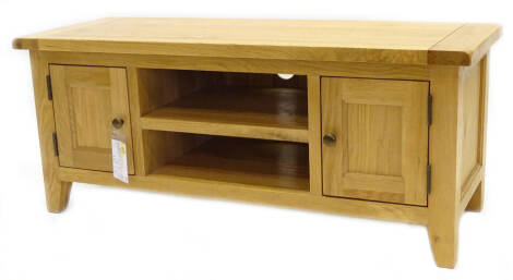 An ex shop display rustic oak large TV unit, with two panel doors and a recess, on square tapering legs, retail price £616.00 reduced to £318.00, 120cm W.