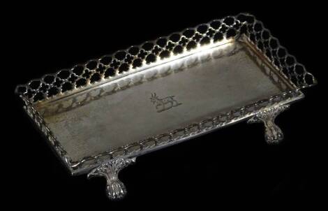 A 19thC Portugese pen tray, of rectangular form, with a lattice work border centred by a goat crest, on quadruple ball an claw acanthus capped feet, with indistinct marks, white metal, 18cm W.