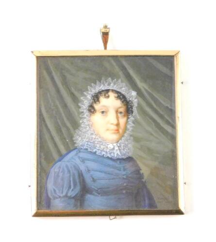 An early 19thC portrait miniature, half length study of a lady in a blue dress with lace collar and bonnet, curtain background, framed, 7cm x 6.5cm.