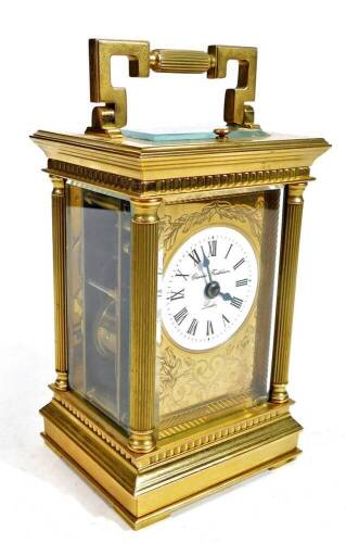 Charles Frodsham, London. A 20thC gilt brass repeating carriage clock, the rectangular five sectional glazed case surmounted by a swing handle, revealing a open movement before a 7cm W back plate, flanked by quarter columns, with Roman numeric dial, sign