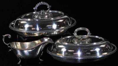 A 19th Old Sheffield Plate sauce boat, with S scroll acanthus capped handle, plain body with upper gadrooned border and triple shell capped hoof feet, 13cm H and two silver plated entree dishes. (3)