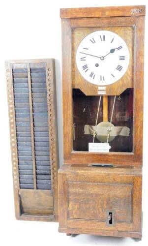 An early 20thC oak clocking in clock, with a shaped case, front articulated till section and glazed upper section, revealing a 26cm Dia. Roman numeric dial, various labels, 113cm H, 40cm W, 41cm D.