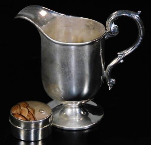 An Edwardian silver cream jug, with a helmet shaped bowl, S scroll handle, inverted stem and circular foot, Birmingham 1907, 9cm H, 2oz and a silver patch box of circular form with domed lid. (2)