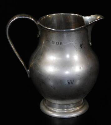 A George V silver cream jug, with bellied circular body, plain handle and beak spout, on circular foot, London 1935, marked Goldsmiths, 11cm H, 4½oz.