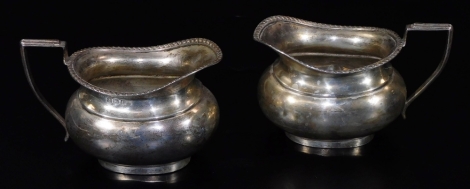 A pair of George VI silver cream jugs, each of oval form with angular strap work handles and a gadrooned border, Birmingham 1939, 6cm H, 5½oz. (2)