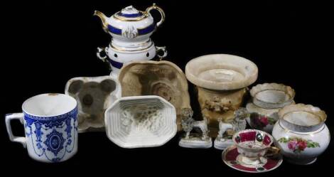 Various 19thC and other pottery, porcelain and effects, to include a pair of Rockingham style poodles, each with bouquets of flowers to their mouths, 11cm H, three pottery jelly moulds, to include one of shaped floral form, an armorial teapot warmer on st