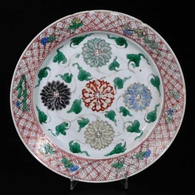 A Chinese porcelain plate, of circular form, polychrome decorated with flowers with an outer geometric floral banding, on circular foot, double line Kangxi mark beneath, 22cm Dia. (AF)