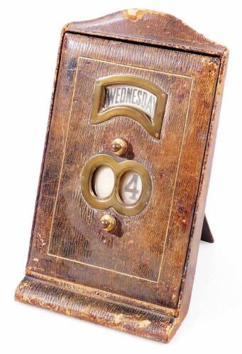 An Art Deco pressed leather desk calendar, of shaped rectangular form, with easel back and articulated date and day to the front, 29cm H.