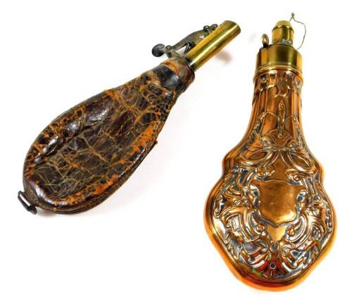 An early 20thC copper and brass powder flask, of tear drop form, heavily repoussé decorated with scrolls and flowers with a vacant cartouche, 21cm H and a further leather shot flask. (2)