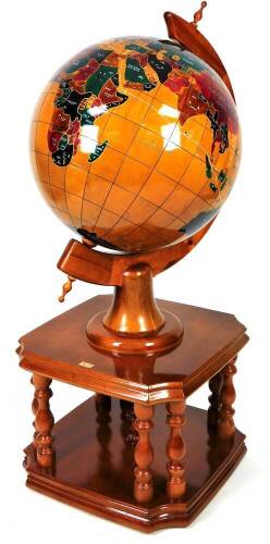 A terrestrial wooden globe, of large proportion, on fixed stand, with baluster supports joined by a platform with inverted corners, the countries picked out in various colours, 140cm H.