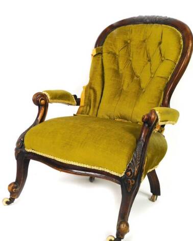 A Victorian mahogany spoon back chair, with carved floral top, overstuffed button back arms and seat, on inverted turned cabriole supports terminating in orb feet with castors, 102cm H.