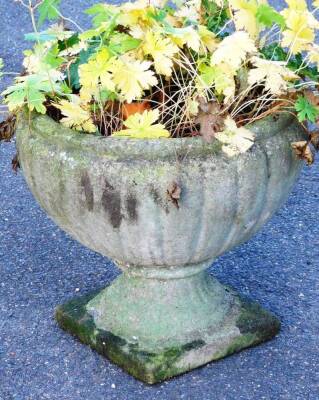 A late 20thC classical design concrete garden urn, the shaped gadrooned bowl on an inverted stem and square foot, 37cm H.