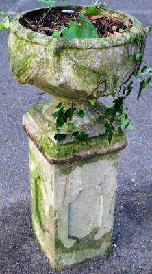 A concrete classical garden urn, the circular bowl raised with a garland, on an inverted stem and square foot, on a plinth base, 88cm H.