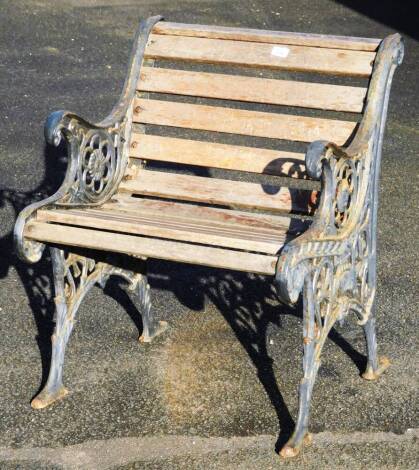 An early 20thC cast iron and slatted wooden garden chair, with shaped floral and mask sides, on shaped feet, 80cm H. With the option of the next lot at the same price.