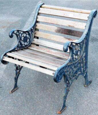 An early 20thC cast iron and slatted wooden garden chair, with shaped floral and mask sides, on shaped feet, 80cm H.