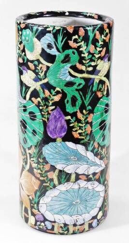 A 20thC Chinese pottery stick barrel, of cylindrical form, profusely decorated with leaves, trees and branches, predominately in green blue and purple, on a black ground, character mark beneath, 48cm H.