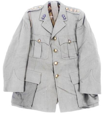 A 20thC army jacket, quarter length with buttons and shoulder epaulettes.