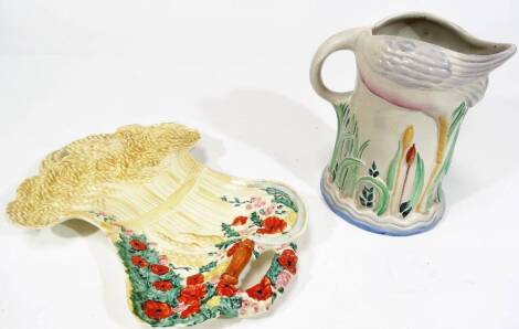 A mid 20thC Clarice Cliff Celtic Harvest pattern Newport Pottery serving dish, polychrome decorated predominately in red, yellow and green, printed marks beneath, 32cm W and a Newport pottery jug partially moulded. (2)