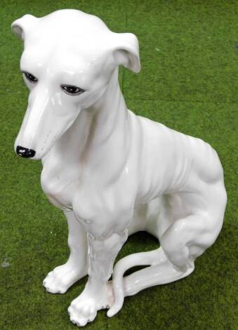 A 20thC Capodimonte style semi porcelain figure, of a seated lurcher in white, 73cm H. (AF)