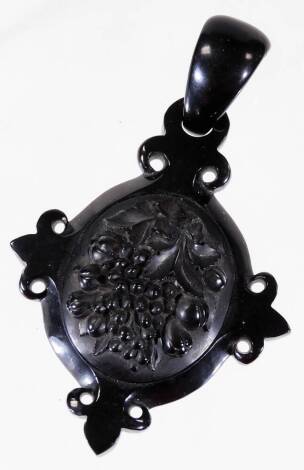 A jet pendant, in the form of a cross with grape and vine centre decoration, and overall polished finish, 6.5cm x 11cm.