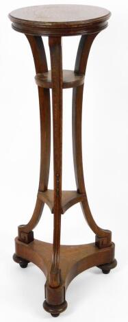 An Empire style oak plant stand, the circular top on triple inverted supports joined by sections, on a platform base terminating in compressed bun feet, 94cm H, the top 30cm Dia.