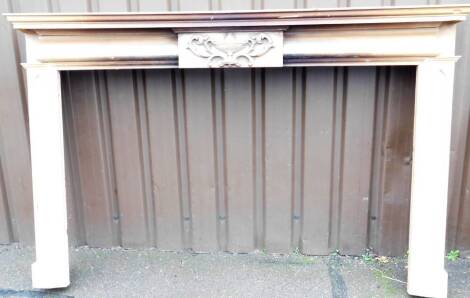 An Adam design pitch pine fire surround, of rectangular form, centred by an urn with scrolls, with shaped mitre sides, probably 19thC, 135cm H, 200cm W, 30cm D.