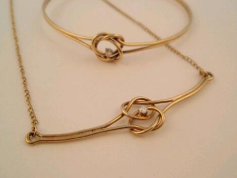 A 9ct gold lovers knot (small diamond set) bangle and pendant set