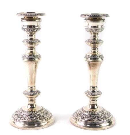 A pair of loaded silver candlesticks, of baluster form, with embossed foliate scroll decoration, Birmingham 1992, 23cm H, 33.50oz.