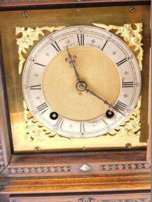 A Victorian oak cased mantel clock, square brass dial with gilt floral spandrels, silvered chapter ring bearing Roman numerals, stated Examd by Dent, 61 Strand, London, eight day movement with coil strike, the case with an arched pediment, turned finials, - 2