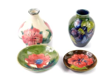 A Moorcroft pottery pin dish, decorated in the Hibiscus pattern, against a brown ground, impressed marks, 8cm Dia, footed dish decorated in the Anemone pattern against a green ground, 9.5cm Dia, vase decorated in the Clematis pattern against a green groun