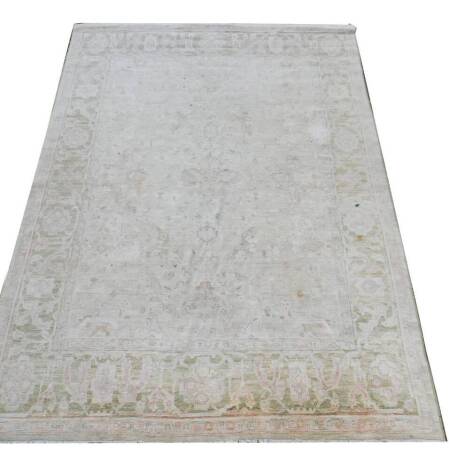 A Pakistan Oushak rug, decorated with floral motifs, against a pale green ground, 378cm x 267cm. (AF)