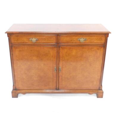 A Georgian style burr yew wood and mahogany cross banded side cabinet, with herringbone inlay, having two drawers above cupboard doors, raised on bracket feet, 91cm H, 121cm W, 40.5cm D.