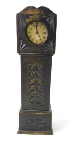 A late 19thC American brass cased bedside clock, contained in a miniature ebonised long case clock case, with carved detailing, 31cm H.