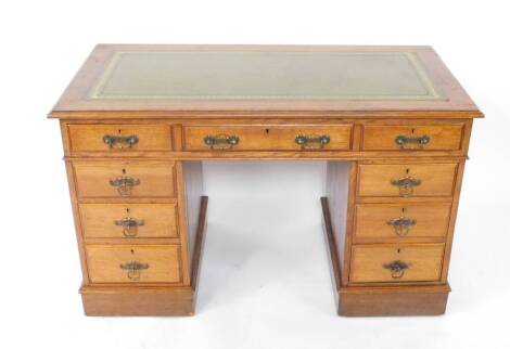 A Victorian oak twin pedestal desk, with a tooled green leather top, over three drawers, above six further drawers, raised on plinth bases, on castors, 76.5cm H, 123cm W, 61cm D.