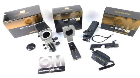 An Olympus OM system slide copier, electronic flash power balance grip II, and auto bellows, all boxed. (3)